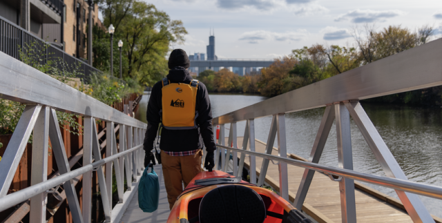 A person is carrying a kayak down a ramp