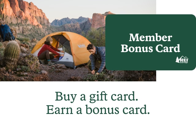 Two campers set up a tent in the desert. Headline: Buy a gift card. Earn a bonus card.